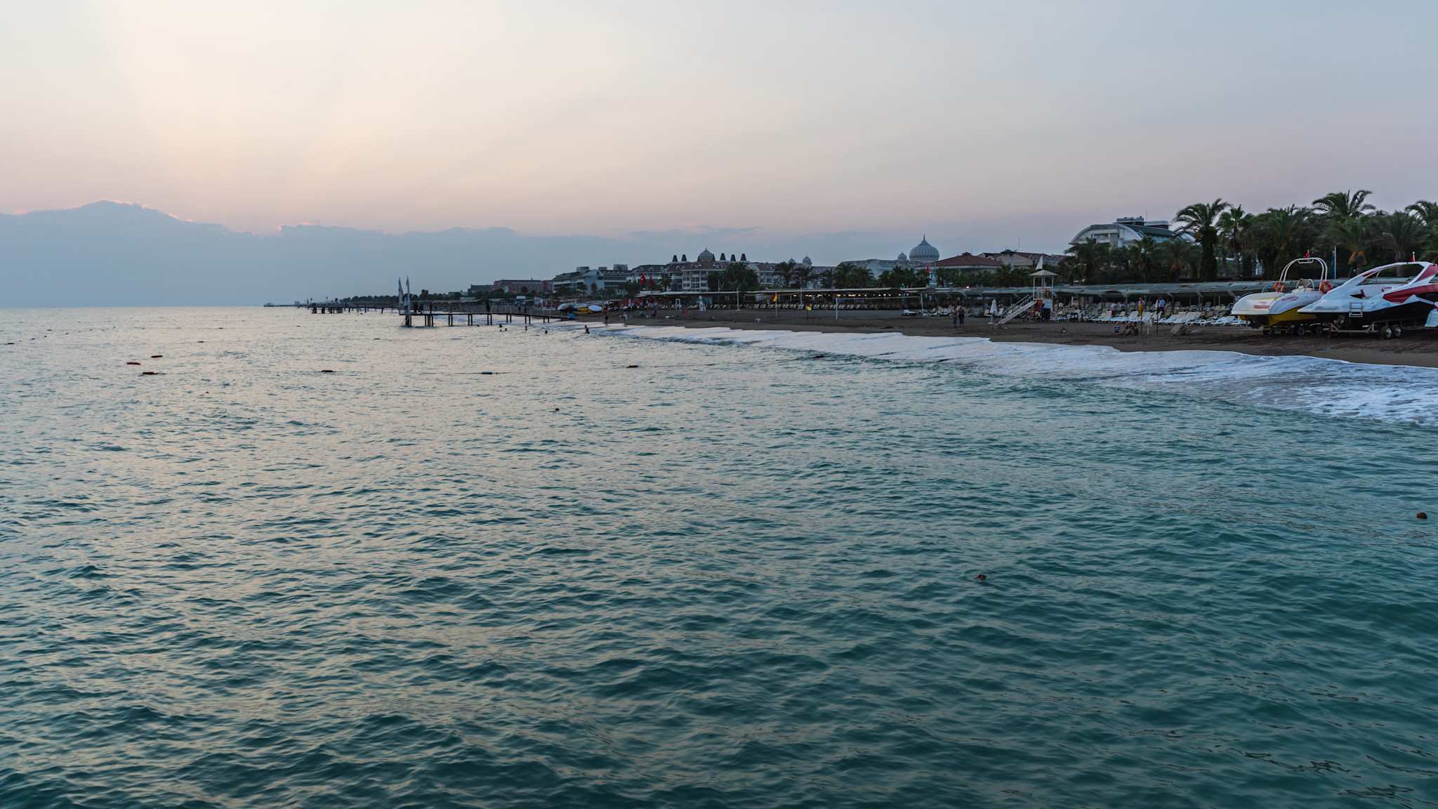 Ein Strand mit Booten und Gebäuden im Hintergrund